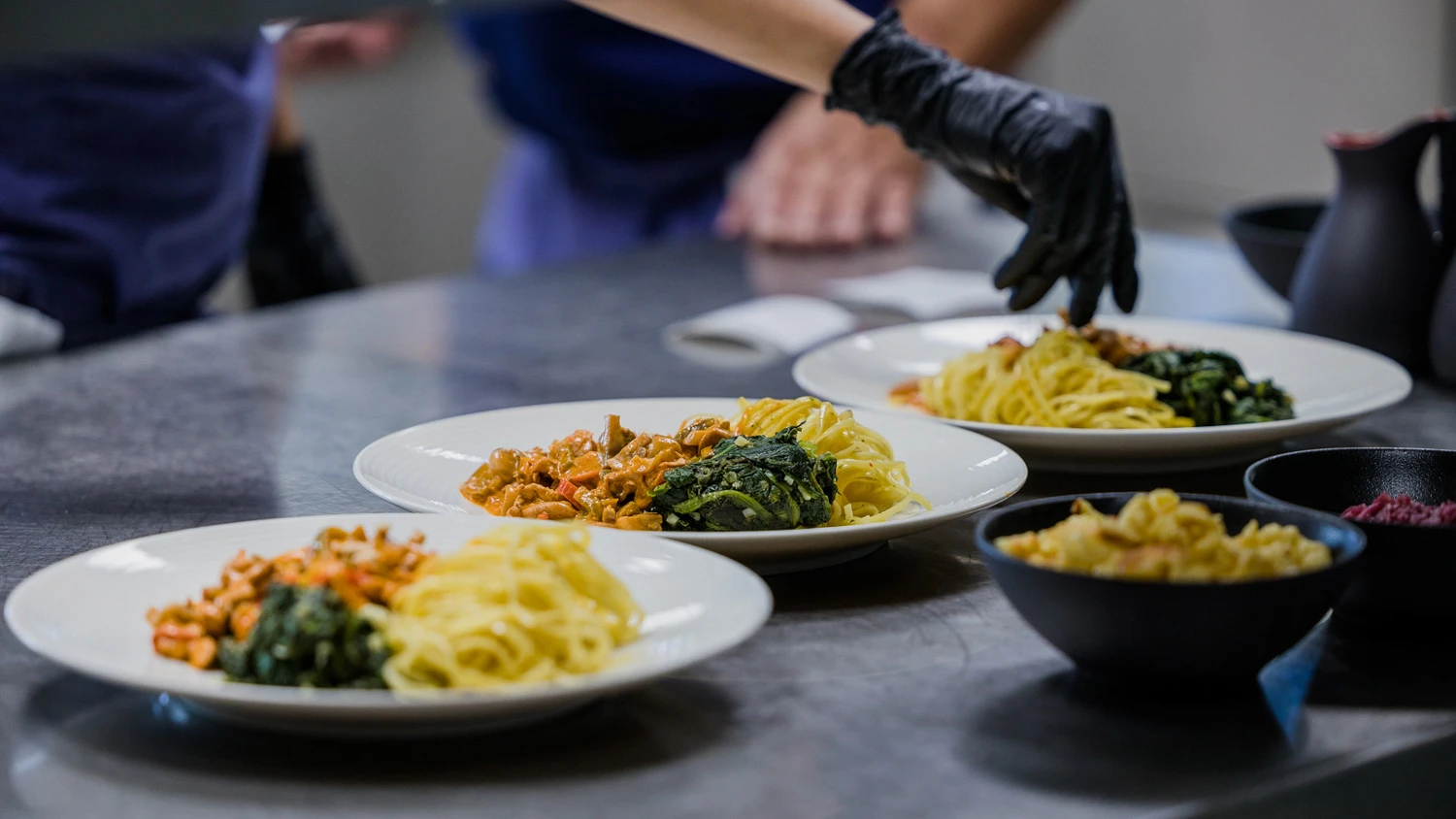Jeune apprenti préparant des assiettes dans une cuisine professionnelle.